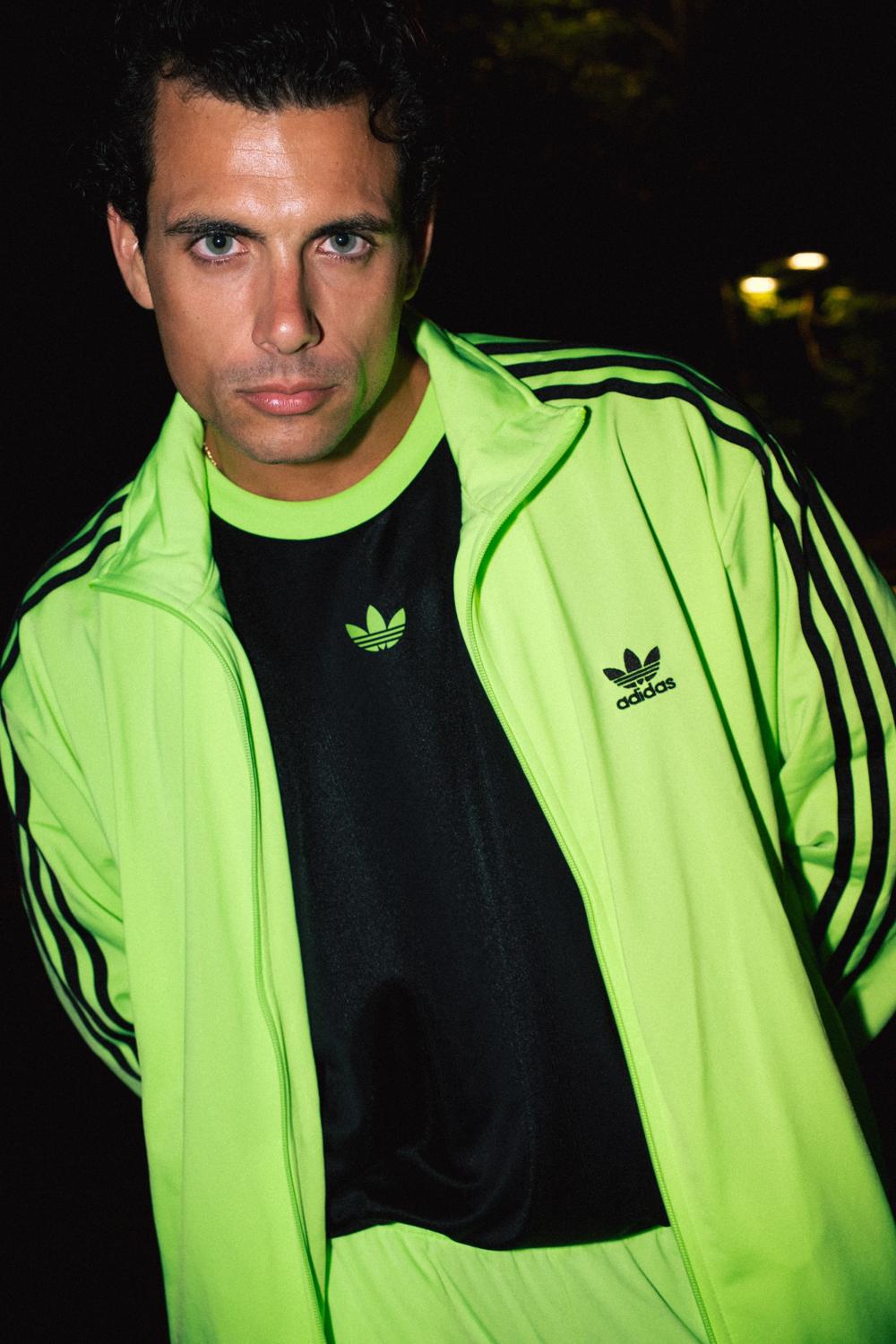 Primer plano de un modelo con chaqueta Adidas amarillo flúor, de noche
