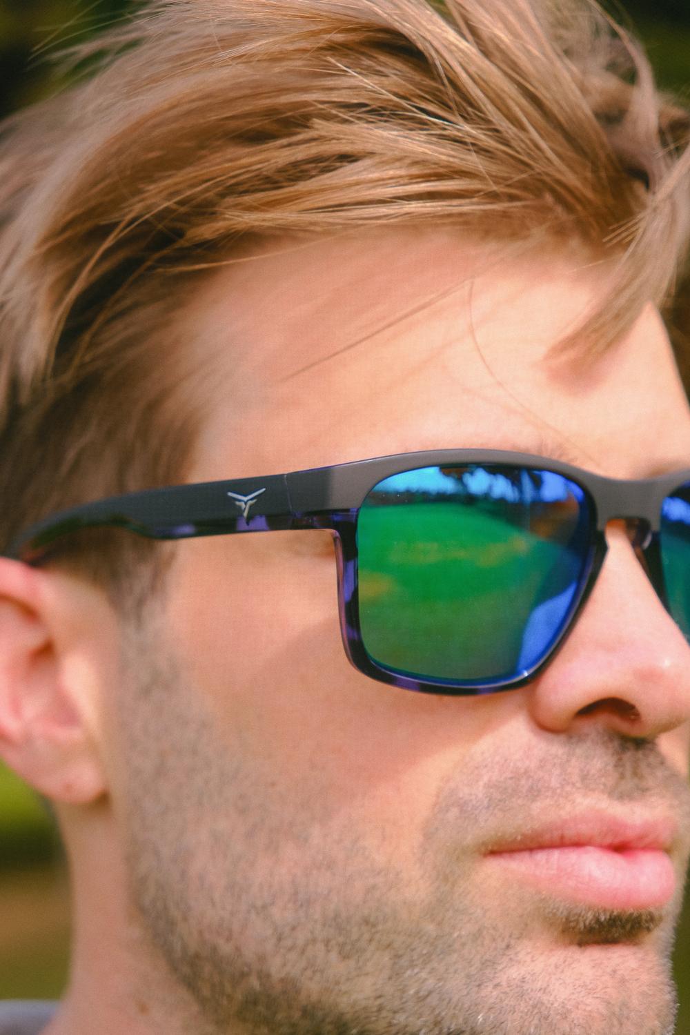 Primer plano de un hombre con gafas de sol de lentes azules